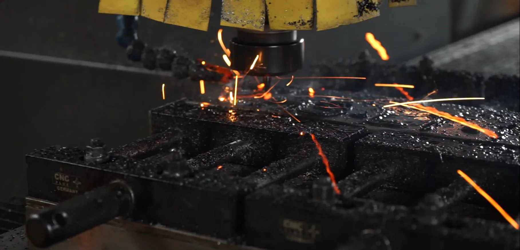 CNC-Fräse bearbeitet ein Metallbauteil mit sichtbarem Funkenflug